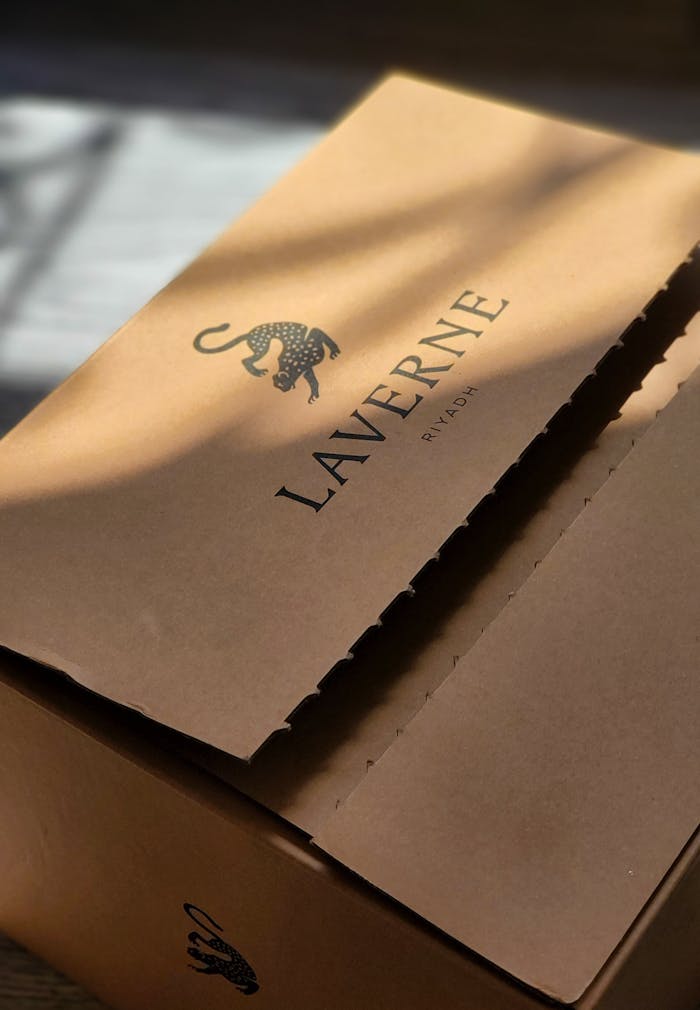 Close-up of Laverne cardboard box with artistic leopard logo, bathed in gentle sunlight.